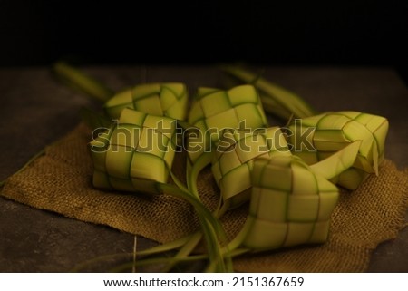 Steamed Rice cake packed inside a diamond-shaped container of woven palm leaf pouch or coconut leaves. Usually served on Special or Religious Feast Isolated Photo 