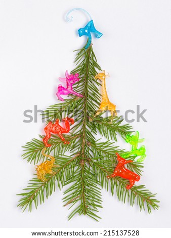 Christmas tree made of fir branches decorated with bright colored toy animals on a white background 
