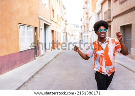 Happy young African American man dancing in the street celebrating and enjoying life. Having fun. Copy space.