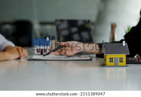 Mortgage loan, Home Insurance and Real estate investment concept, the Sale agent gives a house key to the new client after signing an agreement contract with the approved property application form.