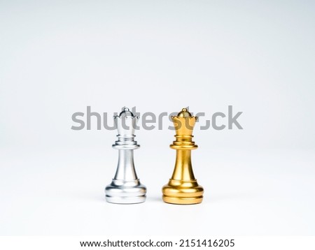A golden queen chess piece and a silver queen chess piece are standing together isolated on white background. Leadership, partnership, competitor, confrontation, and business strategy concept. Royalty-Free Stock Photo #2151416205
