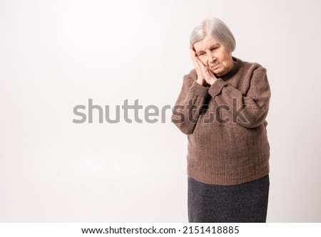Sad elderly woman lay down on folded arms.  Royalty-Free Stock Photo #2151418885