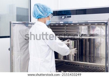 Unidentified operator is prepare the equipment to hot air oven for sterilization to prevent contamination, concept of laboratory, microbiology in pharmaceutical industry. Royalty-Free Stock Photo #2151433249