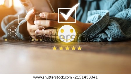 woman's hand using a smartphone to evaluate yellow five-star excellent smiling person Service of different shops or service centers. customer reviews concept. Royalty-Free Stock Photo #2151433341