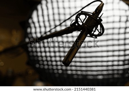 A silhouette of a microphone on an illuminated background