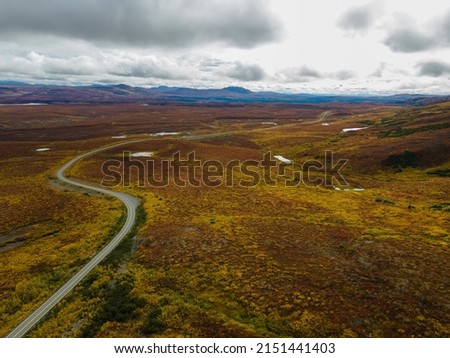An aerial view of the Denali Highway with Alaska Range in autumn colors in the background, Alaska, USA