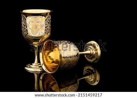Couple Golden Antique Vintage Brass Shot Glass Gilded on black background. metal Wine Cup goblet with Carving Engraving pattern. Royalty-Free Stock Photo #2151459217