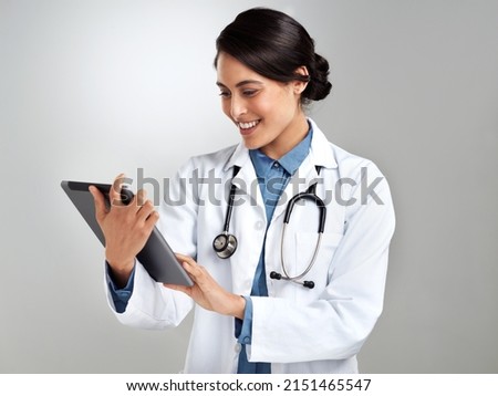 Get connected for medical advice on demand. Studio shot of a young doctor using a digital tablet against a grey background. Royalty-Free Stock Photo #2151465547