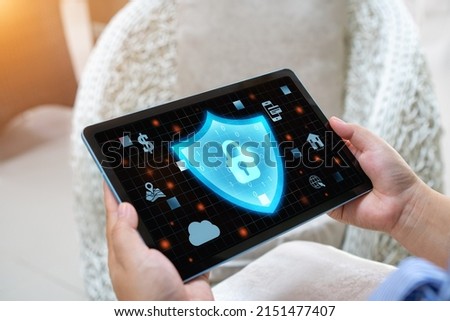 a woman's hand holding a tablet along with graphics of protection from data theft
