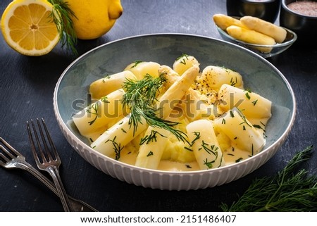 White boiled asparagus in hollandaise sauce with potato puree served on  wooden black table	 Royalty-Free Stock Photo #2151486407
