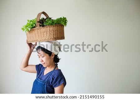 Asian woman farmer holding organic lettuce in the basket on white background.gardening harvesting concept.