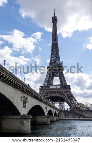 A vertical shot of the Eiffel Tower in Paris, France on cloudy sky background
