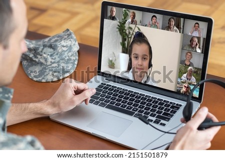 Happy soldier man smiling while making conference call on laptop indoors