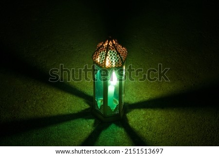 Ornamental Arabic lantern with a burning candle glowing at night  Festive greeting card, invitation for Muslim holy month Ramadan Kareem (Eid Holiday)
