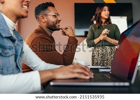 Group of diverse businesspeople having a meeting in a boardroom. Young businesspeople smiling happily during a discussion. Multiethnic businesspeople working together as a team. Royalty-Free Stock Photo #2151535935