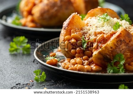 Jacket Baked potato with tomato beans, cheddar cheese. Traditional British food. Royalty-Free Stock Photo #2151538963
