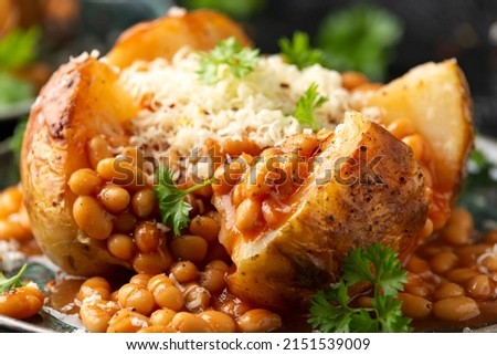 Jacket Baked potato with tomato beans, cheddar cheese. Traditional British food. Royalty-Free Stock Photo #2151539009