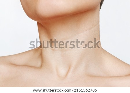 Сlose up of young woman's neck with lines isolated on a white background. Wrinkles, creases, age-related changes, rings of Venus, furrows. Skin care