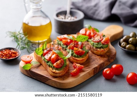 Bruschetta, crostini with pesto and tomato. Grey background. Close up. Royalty-Free Stock Photo #2151580119