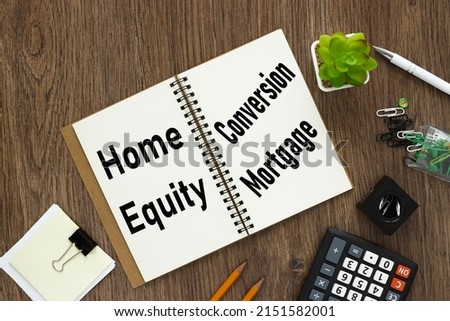 Home Equity Conversion Mortgage HECM open notepad with text near potted plant and calculator