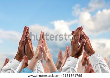 Hands in prayer against the sky. Dlured background. The concept of religious beliefs, confessions, worship. Royalty-Free Stock Photo #2151591765