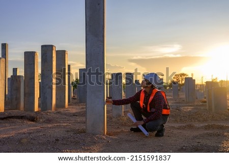 Construction engineers survey checkpoints of concrete pile,  load-bearing piles of the tall building at the construction site evening time. Royalty-Free Stock Photo #2151591837