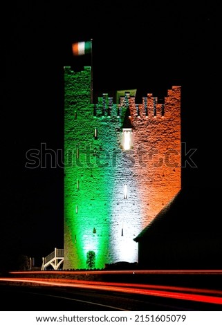 A vertical night shot of Rochester Castle with colorful lights on a long exposure effect with a dark background