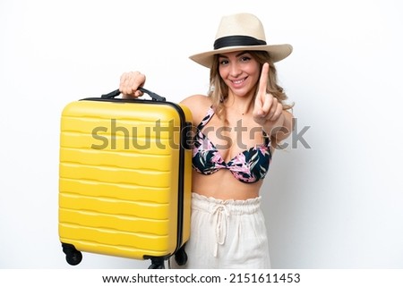 Girl in swimsuit in summer holidays isolated on white background in vacation with travel suitcase and counting one