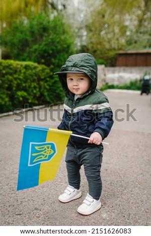 Portrait little baby boy calls to Stop war in Ukraine, raises yellow and blue flag Ukraine. No war, stop war, russian aggression. Little ukrainian patriot. Ukrainian geopolitics globe crisis.