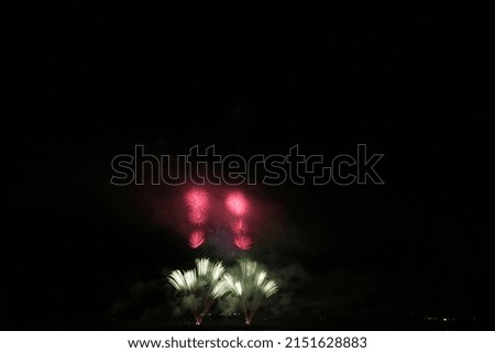 Fireworks display in a town with rivers and mountains