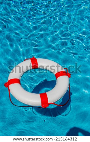 an emergency tire floating in a swimming pool. symbol photo for rescue and crisis management in the financial crisis and banking crisis.