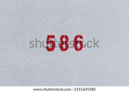 RED Number 586 on the white wall. Spray paint.
