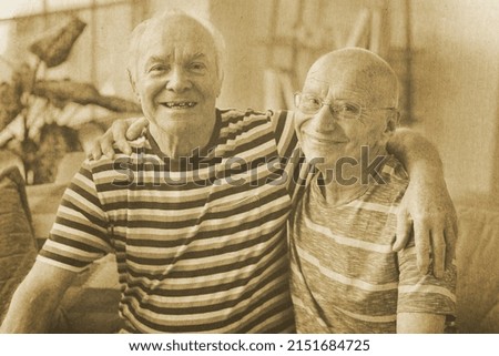Old photo of happy elderly men at home