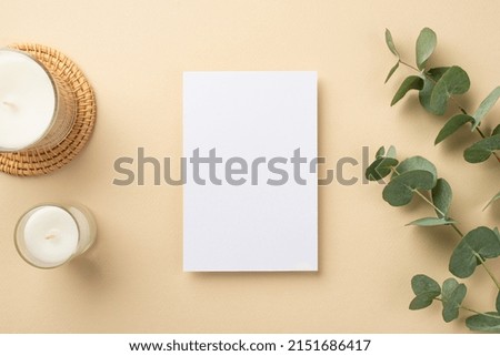 Top view photo of paper sheet candles on rattan placemat and eucalyptus on isolated beige background with copyspace