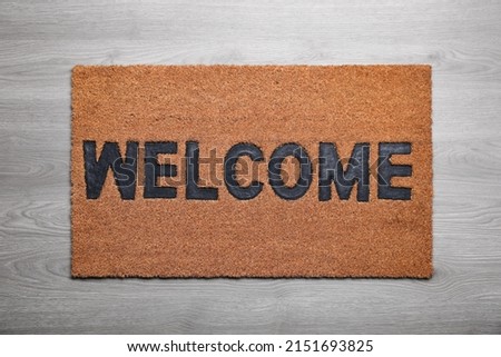 New clean mat with word WELCOME on floor, top view Royalty-Free Stock Photo #2151693825