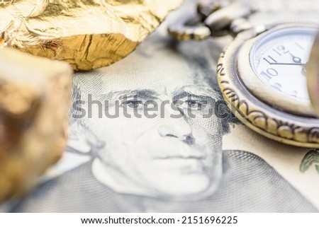 Precious metals and currency investment concept : Gold colored iron ore on a US dollar money, depicting investing in gold market to diversify risk through the use of futures contract and derivatives. Royalty-Free Stock Photo #2151696225