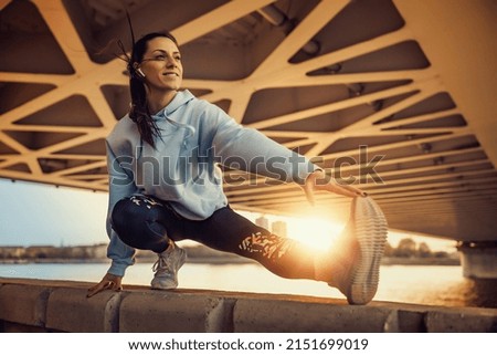 Fitness woman stretching legs after running outdoors.Female athlete taking break after running in the city. Royalty-Free Stock Photo #2151699019