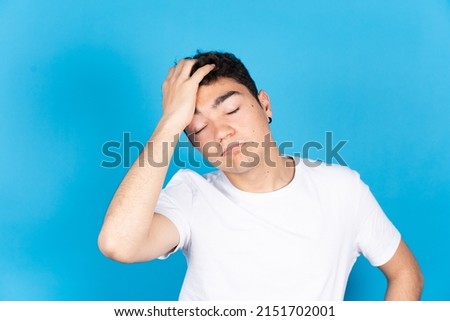 Despaired hispanic teenager boy isolated on blue background. Anxiety, stress and depression concept