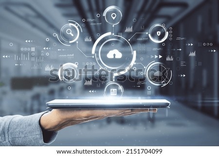 Cloud technology concept with digital tablet on human hand and virtual projection with different cloud service signs: security, loupe, computer and data on blurry office background Royalty-Free Stock Photo #2151704099