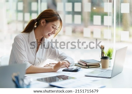 Asian Businessman working to analyze technical price graph and indicator. account or saving money or insurance concept. Royalty-Free Stock Photo #2151715679