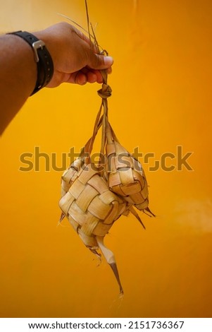 Selective focus of Ketupat with yellow background. Food that is usually served or often encountered during the celebration of Eid al-Fitr.
