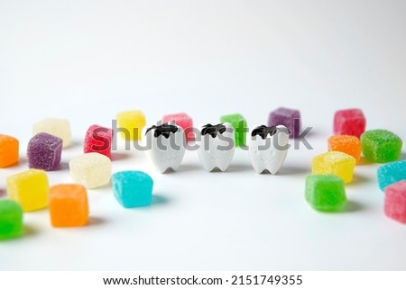 Close up Decay tooth and cubes sweet sugar candy on white background, eat sweet food a lot made toothache and cavities tooth                        