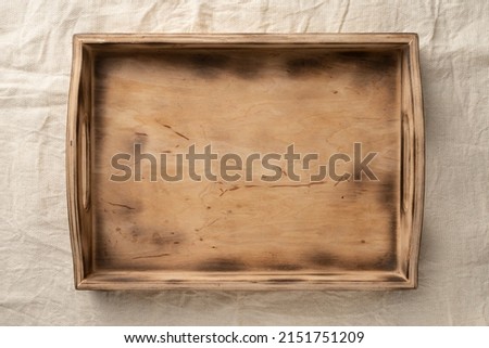 Empty wooden serving box with handles. Farm box made of wooden boards for fruits and vegetables. Open container for food and harvest
