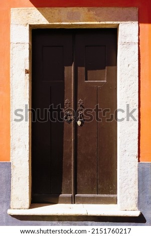 Antique wooden door in orange wall
