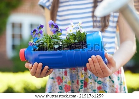 Close Up Of Girl Holding Recycled Plant Holder From Plastic Bottle Packaging Waste In Garden At Home Royalty-Free Stock Photo #2151761259