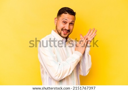 Young hispanic man isolated on yellow background feeling energetic and comfortable, rubbing hands confident. Royalty-Free Stock Photo #2151767397