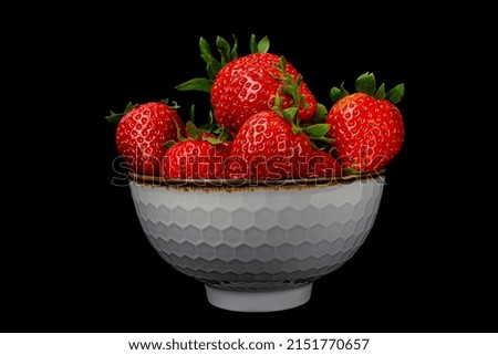 strawberries on a white plate on a black background close-up