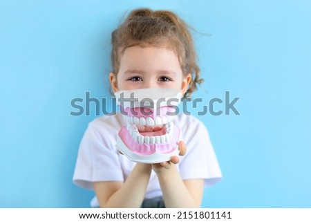 Little cute funny girl holding tooth jaw, dent. Kid training oral hygiene. Child learning brushing, cleaning teeth. Prevention of caries in children. children dentistry. dental care. kid dentist Royalty-Free Stock Photo #2151801141