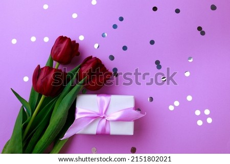 Gift box and spring flowers with confetti  on color background. Stylish soft image of spring flowers. Happy womens day. Happy Mothers day.Hello Spring