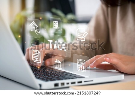 Women use the laptop to fill in the income tax online return form for payment. Government, state taxes. Data analysis, paperwork,Financial research, government taxes, Tax, and Vat concept. Royalty-Free Stock Photo #2151807249